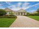Elegant home featuring a large driveway, manicured lawn and landscaping at 6533 Cartmel Ln, Windermere, FL 34786