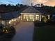 Stunning home exterior featuring lush landscaping, red tile roof, brick driveway, and illuminated entryway columns at 6533 Cartmel Ln, Windermere, FL 34786