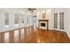 Bright living room with fireplace, hardwood floors, and multiple doors leading to outdoor spaces at 6533 Cartmel Ln, Windermere, FL 34786