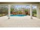 Relaxing outdoor pool area with screened enclosure, stylish tile work, and beautiful landscaping at 6533 Cartmel Ln, Windermere, FL 34786