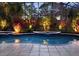Outdoor pool area with screened enclosure and beautiful landscaping highlighted by evening lighting at 6533 Cartmel Ln, Windermere, FL 34786