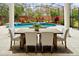 Outdoor dining area featuring a poolside view with lush landscaping and fountain features at 6533 Cartmel Ln, Windermere, FL 34786