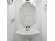 Powder room featuring a pedestal sink, a framed mirror, and decorative wall accents at 10421 Manderley Way # 268, Orlando, FL 32829