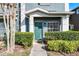 Charming townhouse entrance with a teal-colored door and manicured bushes at 10421 Manderley Way # 268, Orlando, FL 32829