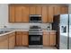 Well-lit kitchen featuring stainless steel appliances, ample wood cabinetry, and durable countertops at 10421 Manderley Way # 268, Orlando, FL 32829