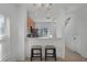 Kitchen view from dining area with breakfast bar and two cushioned stools at 10421 Manderley Way # 268, Orlando, FL 32829
