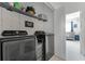 Well-organized laundry room with modern machines, open shelving and a stylish chevron wall pattern at 10421 Manderley Way # 268, Orlando, FL 32829