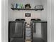 Modern laundry room with sleek appliances, decorative shelving and a convenient storage cart at 10421 Manderley Way # 268, Orlando, FL 32829