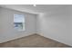 A bright bedroom featuring a large window with natural light and neutral walls and carpet at 12043 Holystone St, Winter Garden, FL 34787