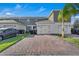 The driveway is paved with red bricks and leads to attached garages at 12043 Holystone St, Winter Garden, FL 34787