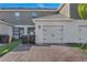 View of a two car garage and brick paver driveway on a well maintained homesite at 12043 Holystone St, Winter Garden, FL 34787