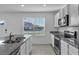 An open-concept kitchen with white cabinets, granite countertops, and stainless steel appliances at 12043 Holystone St, Winter Garden, FL 34787