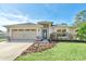 Charming single-story home featuring a well-maintained lawn, a two car garage, and fresh landscaping at 12438 Pine Glen Dr, Leesburg, FL 34788