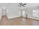Bright living room featuring wood-look floors, a modern ceiling fan, and natural light from two windows at 1245 13Th St, Orange City, FL 32763