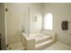 Clean bathroom with a soaking tub, glass shower, and tile surround at 12826 Forestedge Cir, Orlando, FL 32828