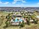 Aerial view of a community pool, and clubhouse surrounded by palm trees and residential neighborhood at 16521 Prairie School Dr, Winter Garden, FL 34787