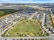 Aerial view of neighborhood featuring a soccer field and playground surrounded by green spaces and homes at 16521 Prairie School Dr, Winter Garden, FL 34787