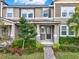 Inviting townhome entrance with manicured bushes, mulched flowerbed, and a brick-paved walkway at 16521 Prairie School Dr, Winter Garden, FL 34787