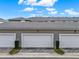 A row of garages with three bays and small shrubs in front at 16521 Prairie School Dr, Winter Garden, FL 34787