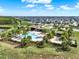Community pool and clubhouse surrounded by manicured green spaces and palm trees in a residential neighborhood at 16521 Prairie School Dr, Winter Garden, FL 34787