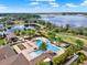 Aerial view of a pool with palm trees and lounge chairs near the lake and surrounding green space at 16521 Prairie School Dr, Winter Garden, FL 34787