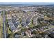 Aerial view showcases a well-maintained townhome community with lush greenery and lake views at 17438 Promenade Dr, Clermont, FL 34711