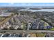 An aerial view of a townhome community, landscaped lawns, a swimming pool, and a scenic lake in the background at 17438 Promenade Dr, Clermont, FL 34711
