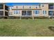 Expansive backyard view with lush lawn, privacy hedges, and access to screened in patio at 17438 Promenade Dr, Clermont, FL 34711