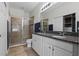 Bathroom featuring double sinks, granite countertop, and a separate tiled shower stall at 17438 Promenade Dr, Clermont, FL 34711