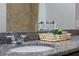 Bathroom features granite countertop with chrome faucet and decorative basket near mirror at 17438 Promenade Dr, Clermont, FL 34711