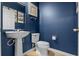 Chic powder room features a pedestal sink and blue walls with classic decor at 17438 Promenade Dr, Clermont, FL 34711