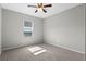 Neutral bedroom featuring soft carpet, ceiling fan, and bright window with shade at 17438 Promenade Dr, Clermont, FL 34711