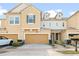 A charming townhome featuring a two-car garage, neutral stucco, and an inviting walkway at 17438 Promenade Dr, Clermont, FL 34711