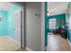 Hallway with gray walls leading to bedroom with bright aqua accent wall at 17438 Promenade Dr, Clermont, FL 34711