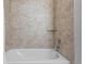 Shower and tub with decorative tan tiling and chrome fixtures at 17438 Promenade Dr, Clermont, FL 34711