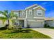 Two-story house with green exterior, two-car garage, and palm tree at 1756 Chatsworth Cir, St Cloud, FL 34771