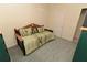 Simple bedroom with a twin daybed, a green and brown floral cover, and neutral walls and carpet at 1809 Wedgewood Way, Kissimmee, FL 34746