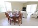 Open dining room with a glass-top table, comfortable seating for six, and sliding door access to outdoors at 1809 Wedgewood Way, Kissimmee, FL 34746