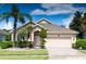 Charming single-story home featuring a well-manicured lawn, mature palm trees, and an attached two-car garage at 1809 Wedgewood Way, Kissimmee, FL 34746