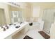 Well-lit bathroom featuring a large mirror, double vanity, a soaking tub, and a separate glass-enclosed shower at 1809 Wedgewood Way, Kissimmee, FL 34746