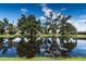 Scenic view of a tranquil pond reflecting the surrounding trees and sky, creating a peaceful setting at 1809 Wedgewood Way, Kissimmee, FL 34746