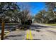 View of the community entrance with landscaping, security gate, and mature trees at 2011 Stockton Dr, Sanford, FL 32771