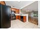Modern kitchen featuring black appliances, tile floors, and cherry cabinets at 2011 Stockton Dr, Sanford, FL 32771