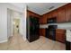 Efficient kitchen layout featuring black appliances, cherry cabinets, and tile floors at 2011 Stockton Dr, Sanford, FL 32771
