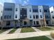 Three-story townhouses with gray and white exterior, landscaping, and walkway at 2221 Valentine Aly, Orlando, FL 32804