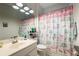 Bright bathroom featuring a vanity with a sink, toilet, and a shower with a colorful curtain at 2351 Fenton Ave, Clermont, FL 34711