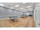 Large game room with hardwood floor, ping pong tables, ceiling fans, neutral paint and access doors at 2351 Fenton Ave, Clermont, FL 34711