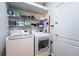 Practical laundry room with white washer and dryer, and shelving for storage at 2351 Fenton Ave, Clermont, FL 34711