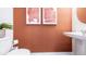 Stylish powder room with terracotta walls and a modern vanity at 2496 Penguin Blvd, Davenport, FL 33837