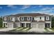 Three-unit townhome building, light beige and dark gray, with three-car garage at 2496 Penguin Blvd, Davenport, FL 33837